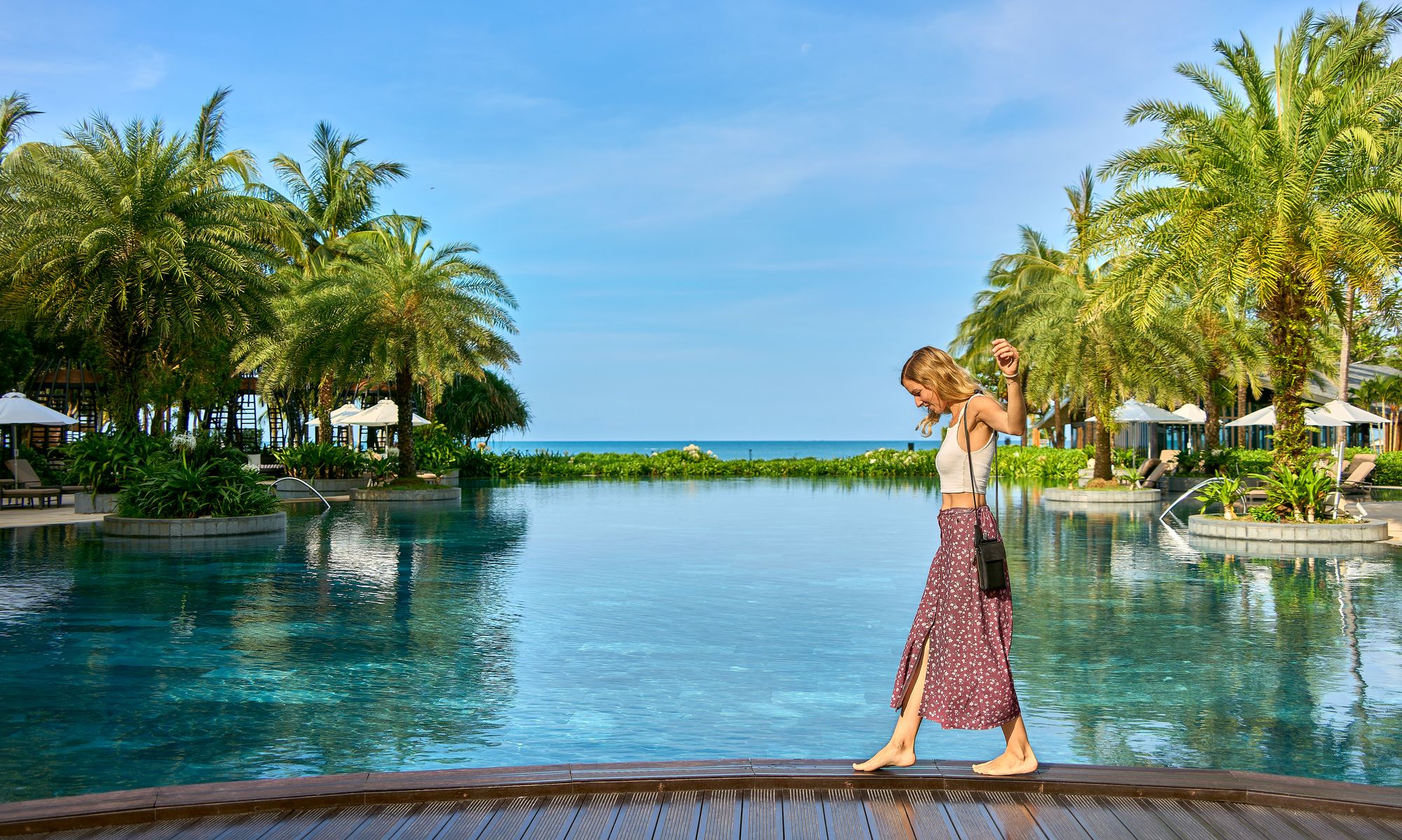 Janet Dannehl at an infinity pool among palm trees